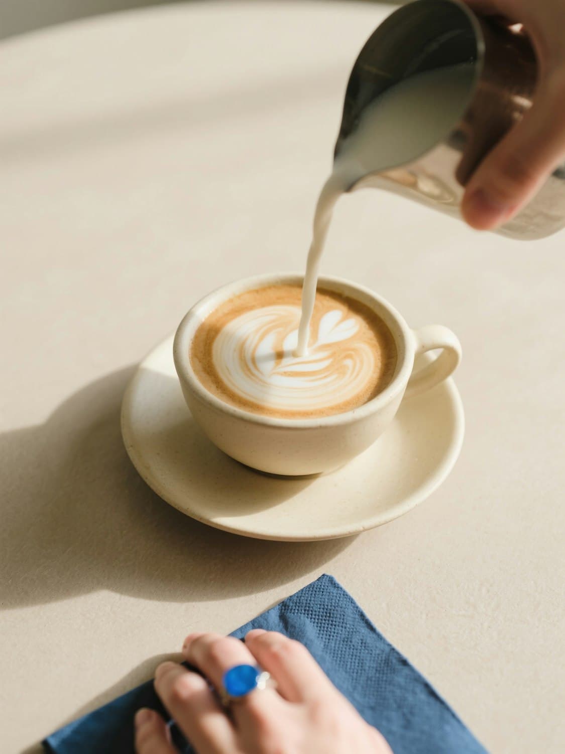 Steamed milk being poured into a cappuccino to make latte art